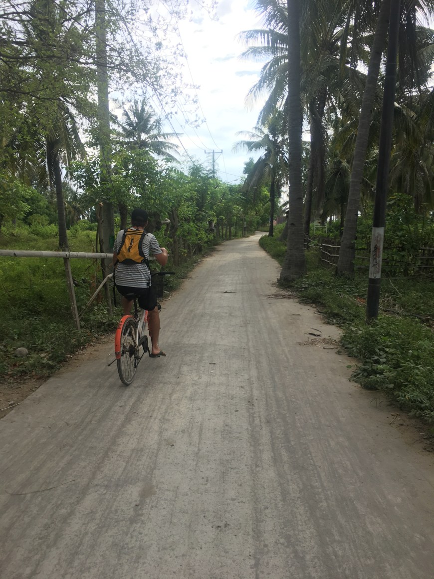 TJ biking into town from our hostel on Gili T