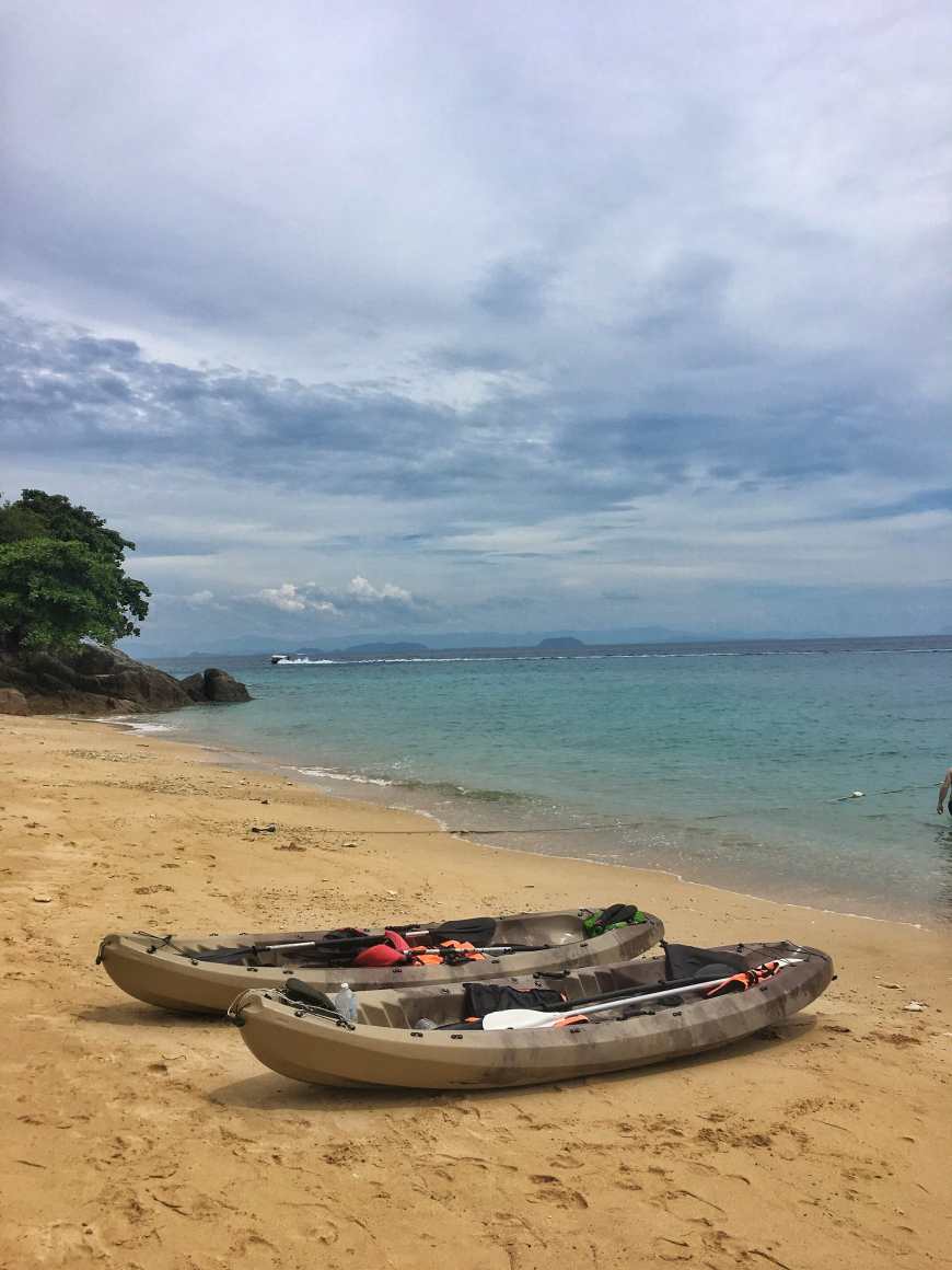 Two kayaks pulled into a beach for some exploring as we kayaked around the island of Perhentian Kecil in Malaysia