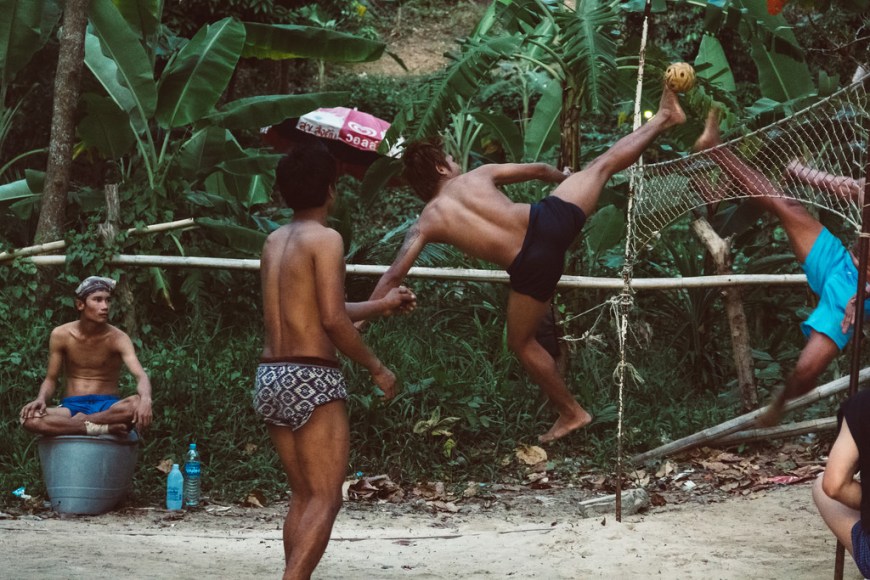 Sepak Takrwa game being played as two men kick the ball over the net