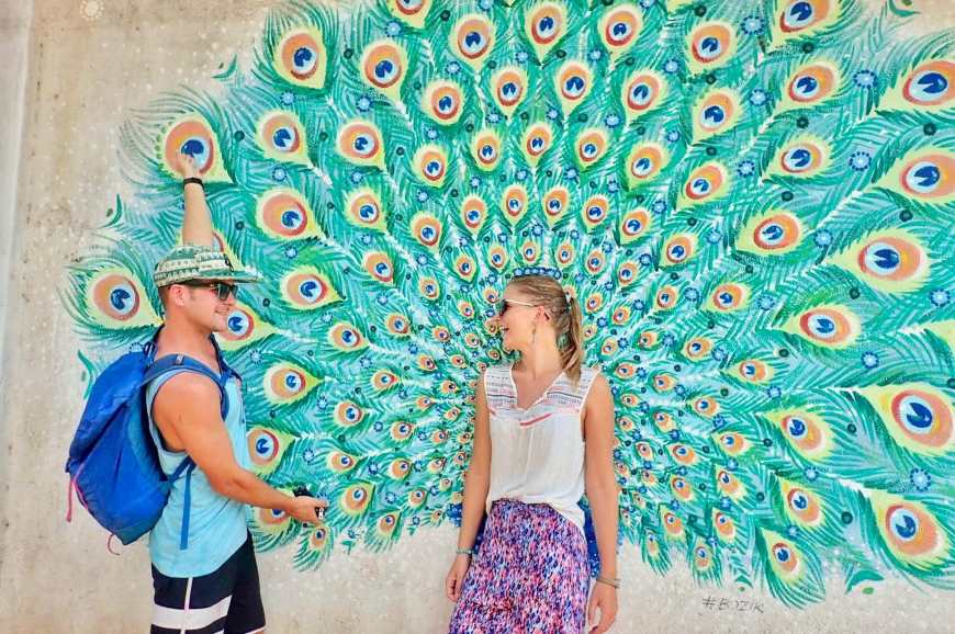Standing in front of a peacock mural having fun laughing together