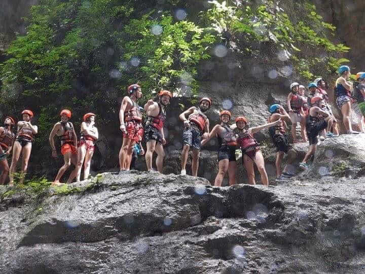 Group of friends standing on a rock cliff while canyoneering in the Philippines
