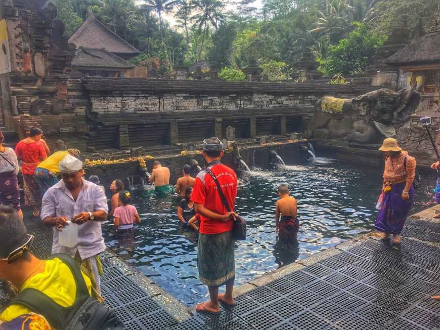 A local guide at TJ & Alli of Life Is Meant For Exploring at Tirta Empul in Bali, Indonesia