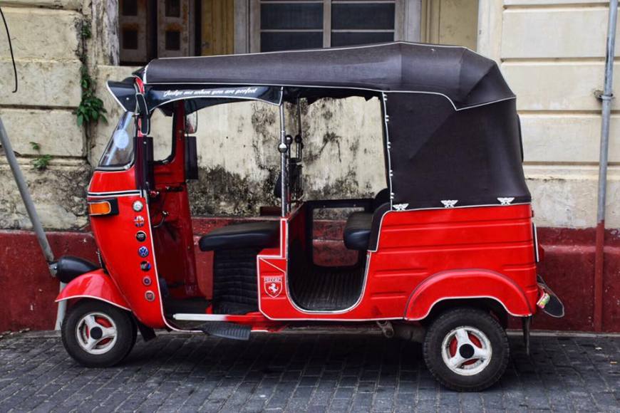 Bright red tuk tuk with a black top on a street in the old fort town of Galle, Sri Lanka